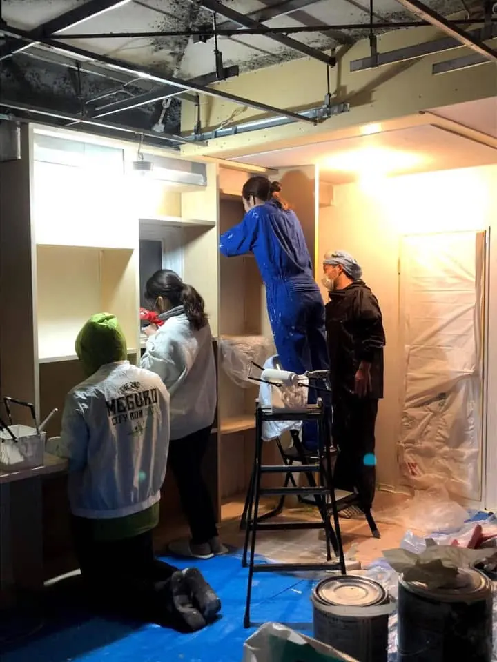 スタッフのみなさんが壁と家具を塗装するDIY作業の様子