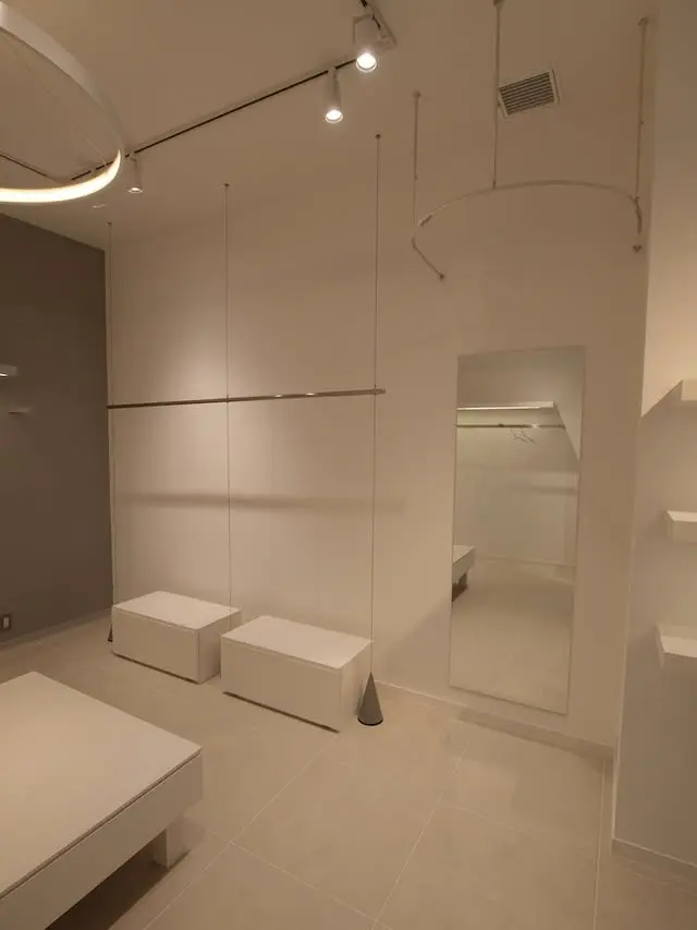 壁面のハンガーパイプと低い展示台