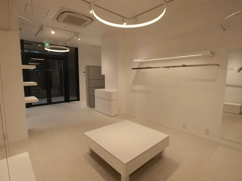 円形照明と白い什器で構成したセレクトショップPaletteの店内